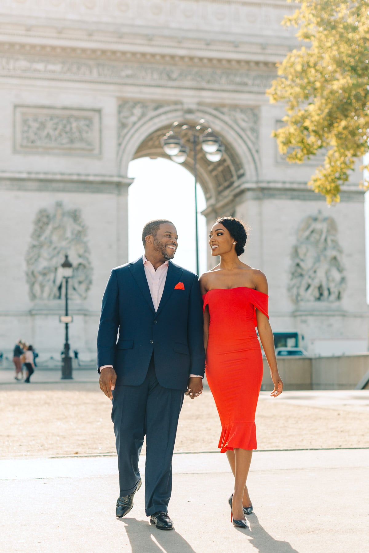couple walking in front of the arc de triomphe paris